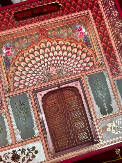 Inspired by the famous Jaipur architecture, this card features a stunning peacock feather arch above a traditional wooden door design.