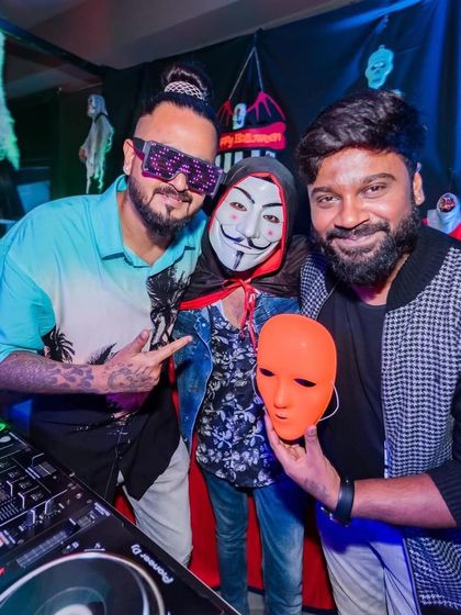 Posing with guests in costume at a Halloween party.