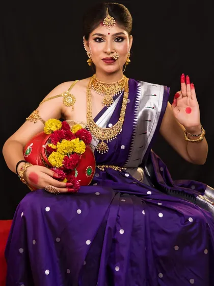 A full seated portrait of Maa Kushmanda, showcasing the rich purple saree and traditional jewelry.