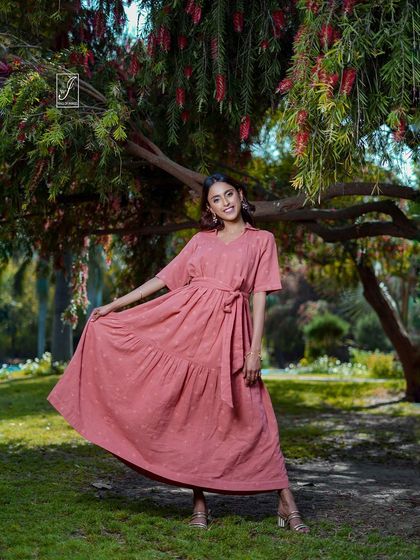 This shot captures the playful movement of the pink summer dress, showing off its tiered skirt and comfortable fit.