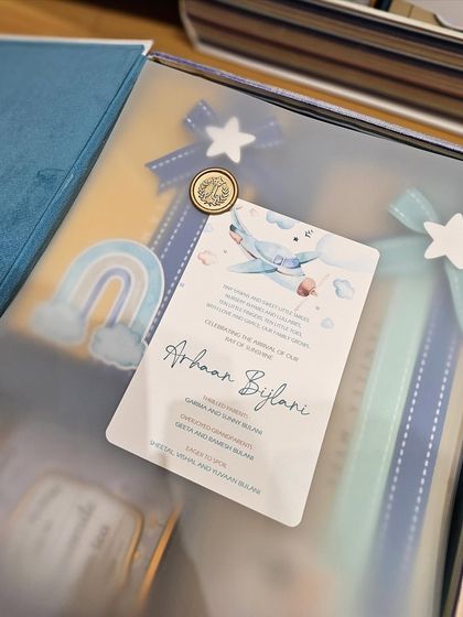 The vellum overlay inside the book box adds a layer of elegance. It features a welcome message for the new baby and is sealed with a custom initialed wax stamp, adding a deeply personal touch.