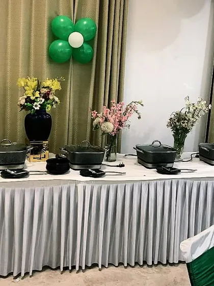 A clean and simple buffet setup with green and white decor. This versatile look is suitable for a wide range of events, from corporate lunches to private parties.