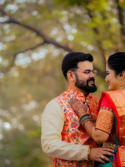 A romantic portrait from behind, showcasing the intricate details of the bride's saree and the couple's connection.