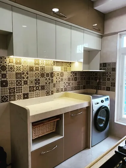 This kitchen features beautiful Moroccan-style tiles for the backsplash, adding a touch of traditional charm to the modern modular setup. The design also includes a dedicated space for the washing machine.