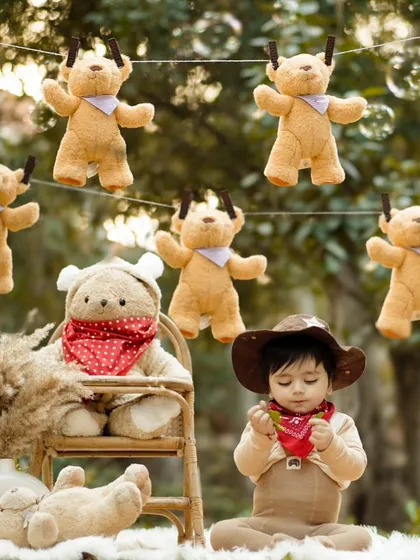 A baby boy interacts with his teddy bear friends while bubbles float around him. This image is a perfect blend of a planned theme and spontaneous, joyful moments.