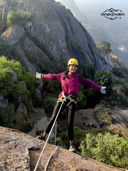 A woman enjoying her rappelling experience, with arms wide open to embrace the thrill.