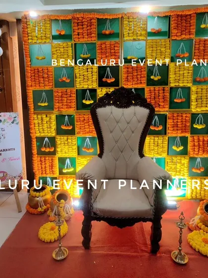 Here is a traditional baby shower setup I arranged in a client's home in Bangalore. It features a vibrant marigold flower wall, a comfortable throne chair for the mother to be, and a personalized welcome sign, blending tradition with a polished look.