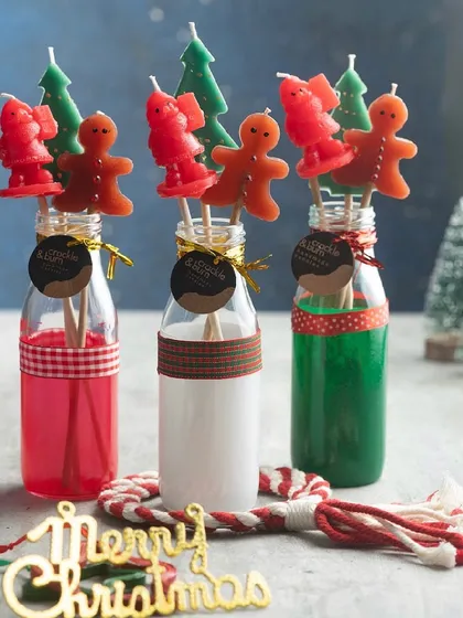 A festive collection of my Christmas candle sticks, featuring gingerbread men, Santas, and trees, all presented in cute milk bottles.