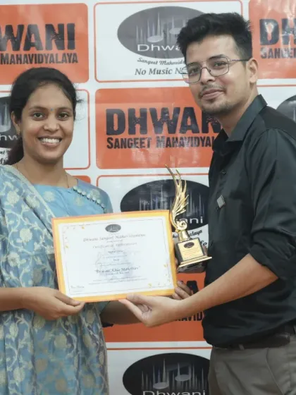 A teacher presents an award to an adult student.