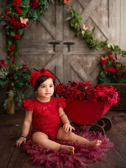 A lovely shot of this little one with a red doll cart, matching her dress perfectly.