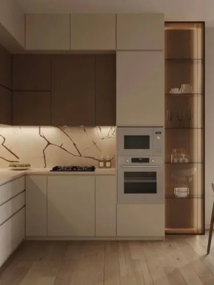 This L-shaped kitchen combines beige and dark wood-toned cabinets for a sophisticated, earthy feel. We added a full-height, back-lit glass pantry for a touch of elegance and practical storage, complemented by a beautiful marble backsplash.