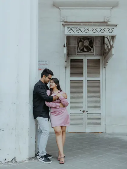 A tender moment shared against a white colonial-era wall in South Mumbai. This kind of simple, elegant backdrop is perfect for focusing on the couple's connection.