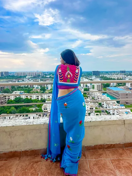 The full back view of the saree and blouse against the city skyline. A modern desi girl look.