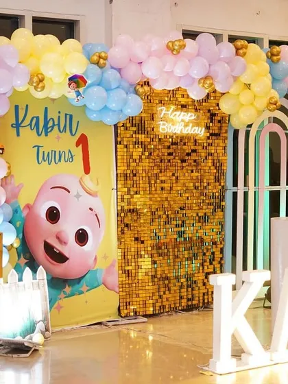 Kabir's Cocomelon party was a pastel dream. The main stage featured a gold sequin wall, a soft-hued balloon arch, and character cutouts.