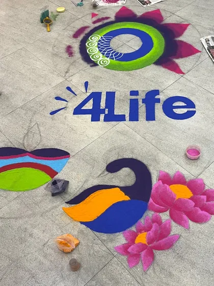 A behind-the-scenes look at a corporate rangoli in progress. The logo and main elements are placed first, and the background and decorative motifs are built around them.