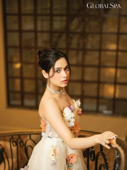 This portrait captures a softer, more contemplative moment from the GlobalSpa editorial. The focus is on the subject's expression, framed by the elegant setting.