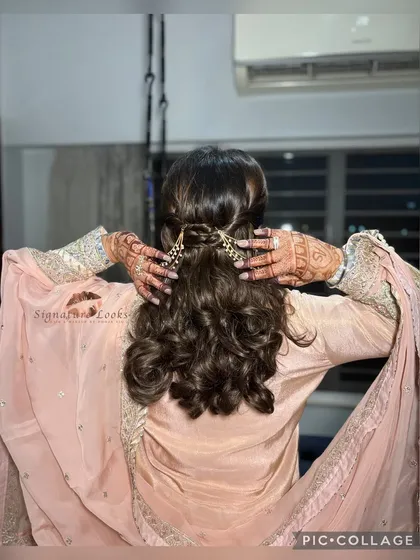A simple yet stunning half-up, half-down style featuring soft curls and a beautiful golden hair accessory. This is an ideal choice for a Roka or engagement ceremony, offering a touch of elegance that complements traditional wear.