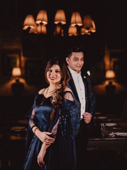 This shot captures the elegant details of the navy blue gown, including the detachable trail and feather-detailed sleeves.