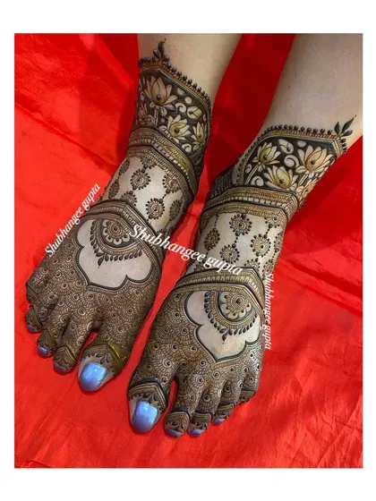 An elegant foot design featuring large mandalas on the top of the foot. The lotus border at the ankle adds a traditional touch to this clean and beautiful design.