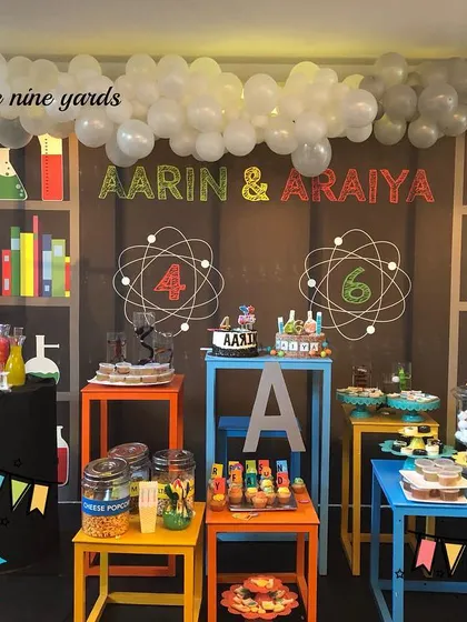 A super fun science lab party for a joint birthday. The backdrop was a shelf of beakers and books, and the balloon arch looked like a chemical reaction in progress.