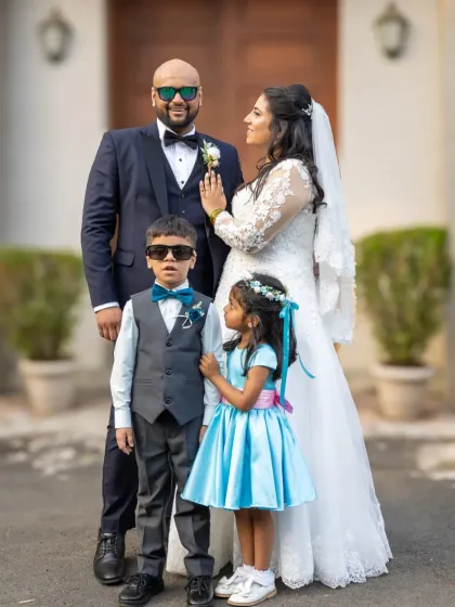 A fun and stylish family portrait. The bride and groom with the page boy and flower girl, who are rocking their own mini sunglasses.