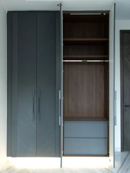 A modern, minimalist wardrobe in a dark grey textured finish. The clean lines and integrated handles offer a sophisticated and understated look, perfect for contemporary bedrooms.