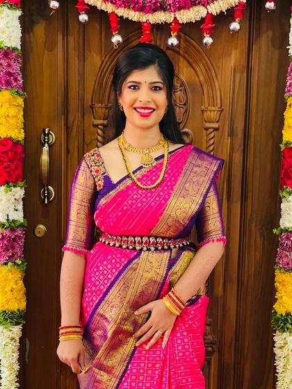 A forever favorite look for a treasured client. This vibrant pink and violet Kanchipuram silk saree is paired with a custom-designed blouse, creating a timeless and elegant ensemble for her special occasion.