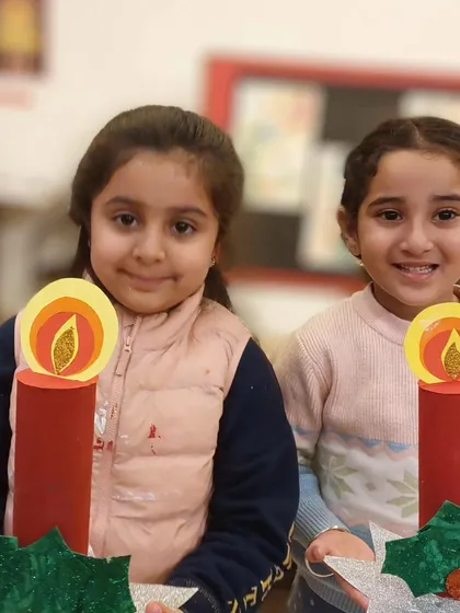 Two students proudly hold up their handmade Christmas candle crafts. These festive projects are a great way for our 5 to 7-year-olds to get into the holiday spirit.