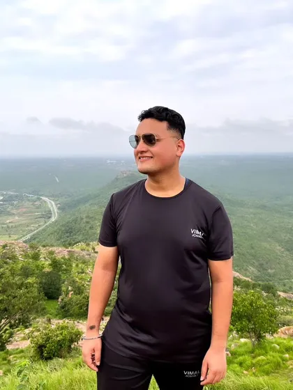 A trekker enjoying the view from the top, with the highway visible in the distance, showing how close this escape is to the city.