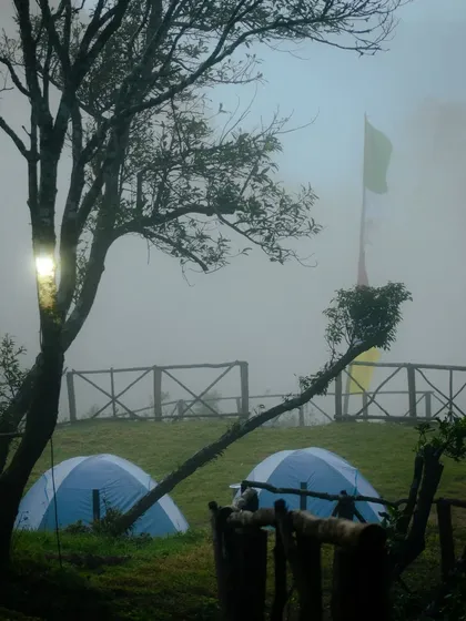 Tents pitched in the misty morning fog, giving the campsite an ethereal and peaceful vibe.