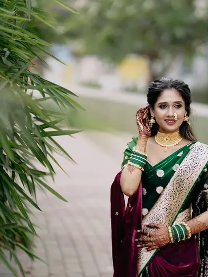 Another lovely portrait of the bride in her green saree. This shot captures her in a classic pose, showcasing the intricate details of her outfit and her elegant posture.