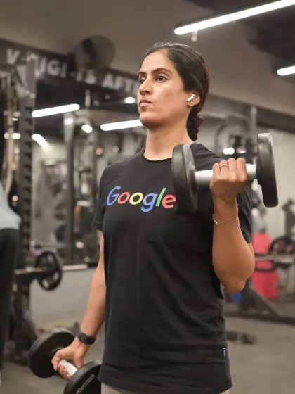 A member performs dumbbell curls, an effective isolation exercise for building bicep strength and definition.