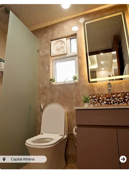 A bathroom with rustic-textured walls and a patterned vessel sink that acts as a centerpiece. The large backlit mirror provides excellent, flattering light.