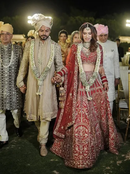 The grand entrance. Her complete bridal look, from the stunning red lehenga to the soft, glowing makeup, creates an unforgettable impression.