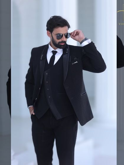 A cool and confident shot of a groom in a classic black suit, perfect for a reception.