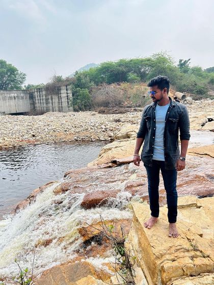 Standing by a small waterfall, a perfect spot for a quick break during a road trip.