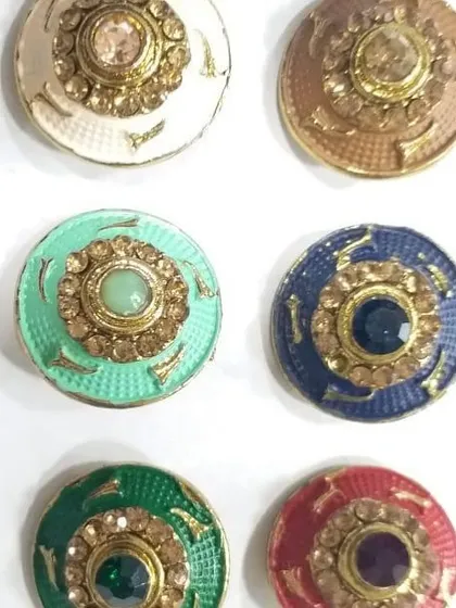 A vibrant assortment of our stone-studded buttons. Available in a range of colors including red, green, blue, and mint, these buttons feature a central colored stone surrounded by a ring of smaller crystals.