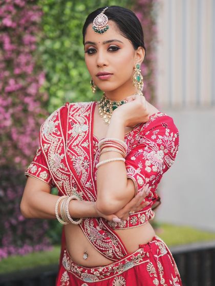 A complete bridal look featuring a heavy, gold-plated Kundan necklace, haath phool, and maang tikka, all available for rent.