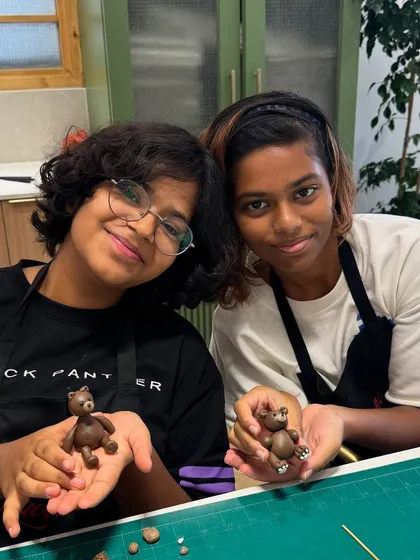 Teamwork makes the dream work! These two talented bakers are showing off the cute little fondant bears they sculpted during our kids' workshop. It's amazing to see their creativity come to life.