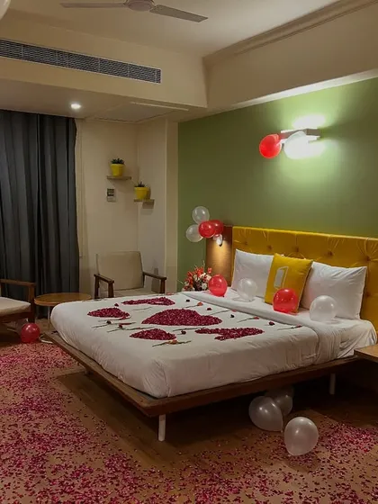 Another angle of the romantic bedroom decoration, showing the overall ambiance with the balloons and flower petals spread across the room.