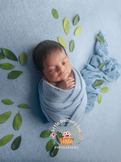 A creative take on the wrapped newborn pose, with green leaves arranged to look like butterfly wings. It's a sweet and artistic way to capture your little one.