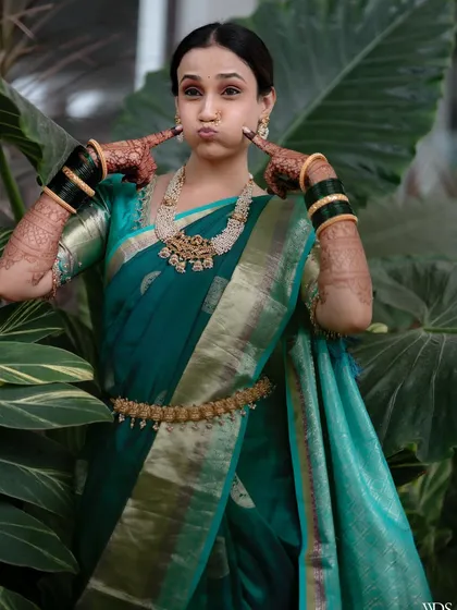 A bride's personality should always shine through. This playful shot captures her bubbly spirit, while also showing off the details of her Maharashtrian engagement look, including the classic green glass bangles and gold kamarbandh.