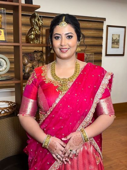 This custom pink half-saree lehenga is a perfect choice for an engagement or pre-wedding event. The blouse features intricate gold embroidery, and the flowing skirt adds a touch of modern grace.