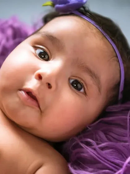 A close-up portrait showing a baby's thoughtful and gentle expression. I use soft lighting to highlight their delicate features.