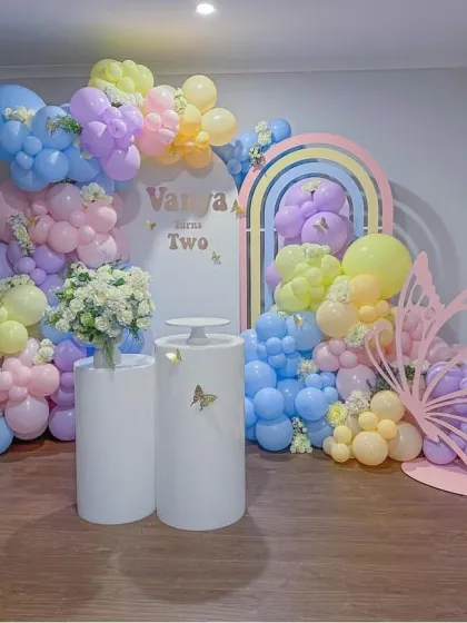 A soft and modern take on a butterfly theme for Vanya's second birthday. This design combines pastel rainbow arched backdrops with delicate butterfly cutouts and a beautiful balloon arrangement in soft, airy colors.