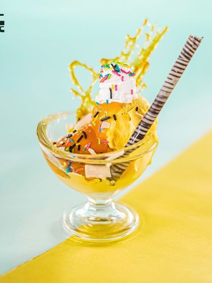 A decadent Banana Split Sundae, complete with sprinkles and a chocolate stick. It's the perfect way to end your meal on a sweet note.