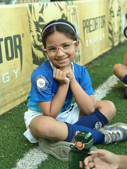 A happy student from our toddlers' program takes a break during a fun-filled session. We make learning the fundamentals of football an enjoyable experience for our youngest players.