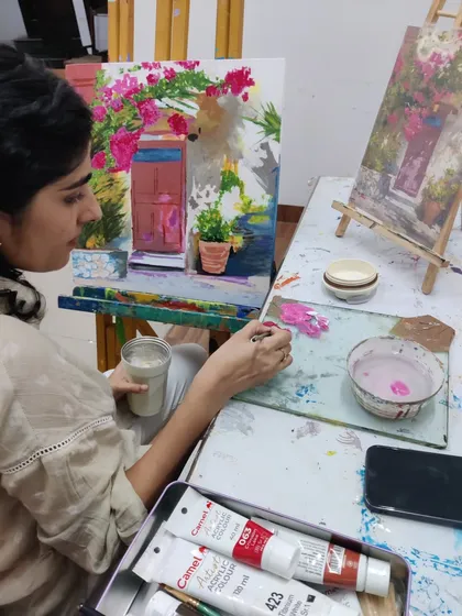 This series captures an adult student working on two different acrylic paintings, one a floral doorway and the other an abstract piece, showing the variety of styles we teach.