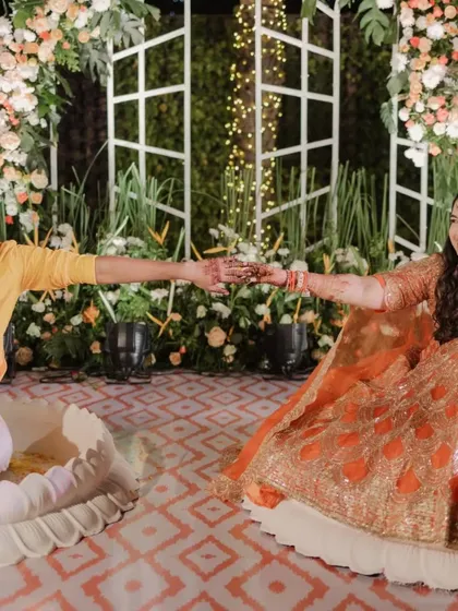 A quiet moment of connection between the couple during their Haldi ceremony, set against a backdrop of lush greenery and floral arrangements.