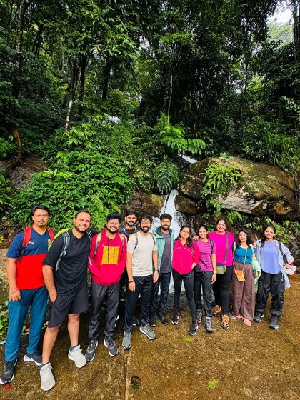 The group takes a break at a small, serene waterfall during the Tadiandamol trek.